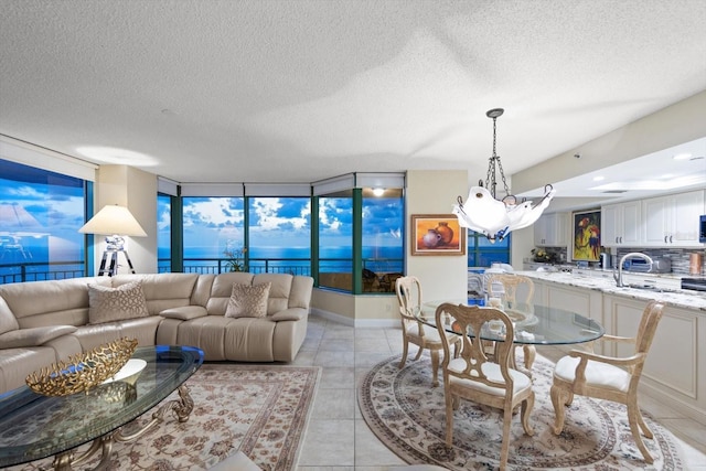 living area with light tile patterned floors, a textured ceiling, and a chandelier