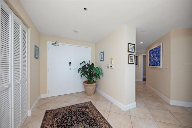 hallway with light tile patterned floors, recessed lighting, and baseboards