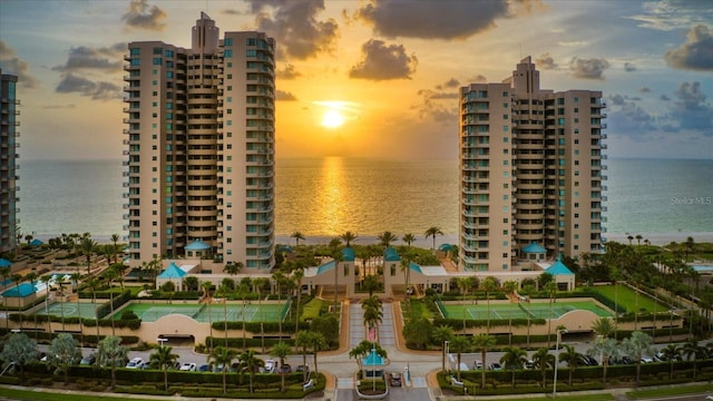property at dusk with a water view