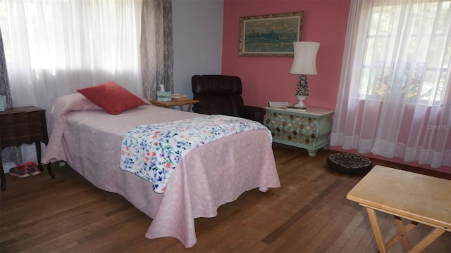 bedroom with multiple windows and hardwood / wood-style floors