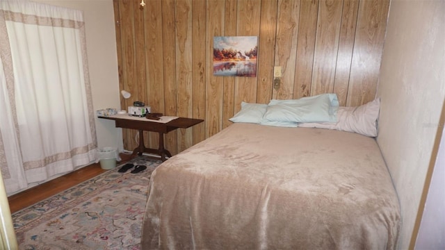 bedroom featuring wooden walls and hardwood / wood-style floors