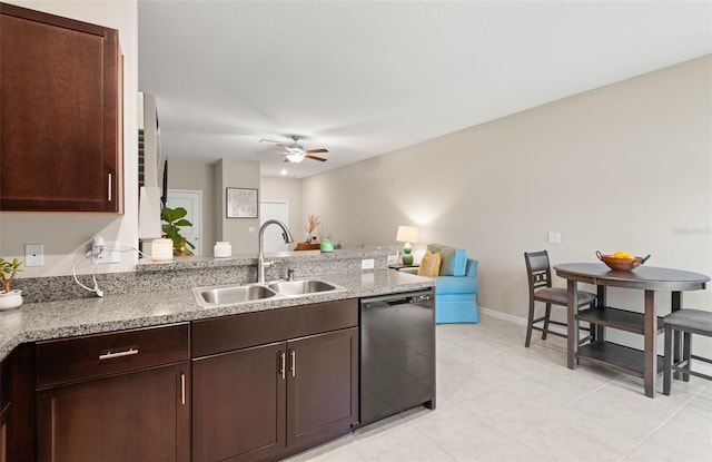 kitchen with sink, light stone counters, ceiling fan, dark brown cabinets, and black dishwasher