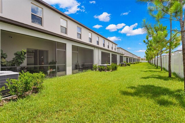 view of yard featuring central AC unit and a sunroom