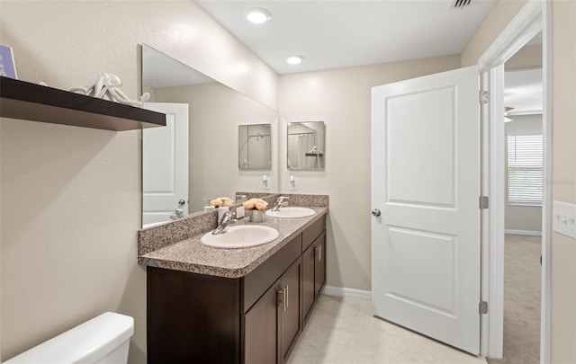 7203 Sweet Alyssum Ct, Tampa, FL 33619 - bathroom featuring double vanity, toilet, baseboards, and a sink