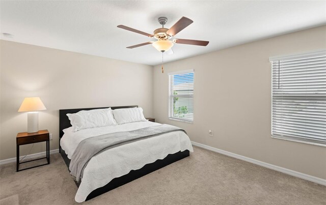 bedroom featuring light colored carpet and ceiling fan