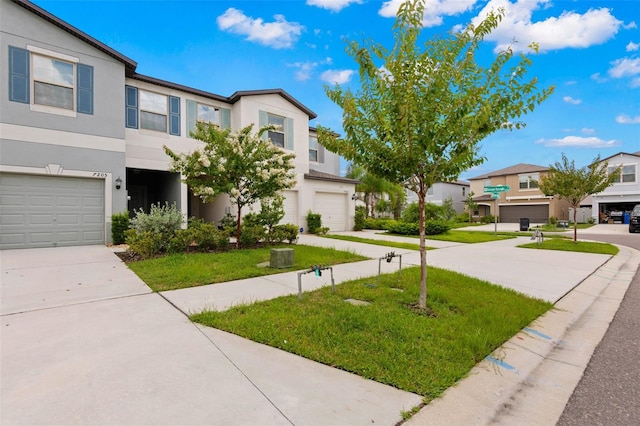 townhome / multi-family property with a garage and a front lawn