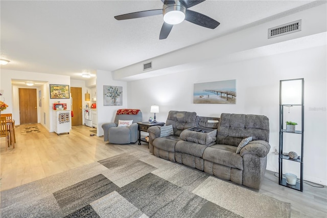 living room featuring wood-type flooring and a textured ceiling