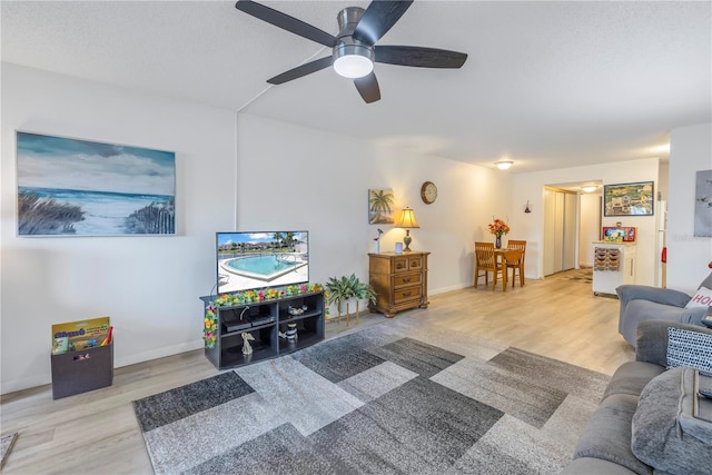 living room featuring light hardwood / wood-style flooring and ceiling fan