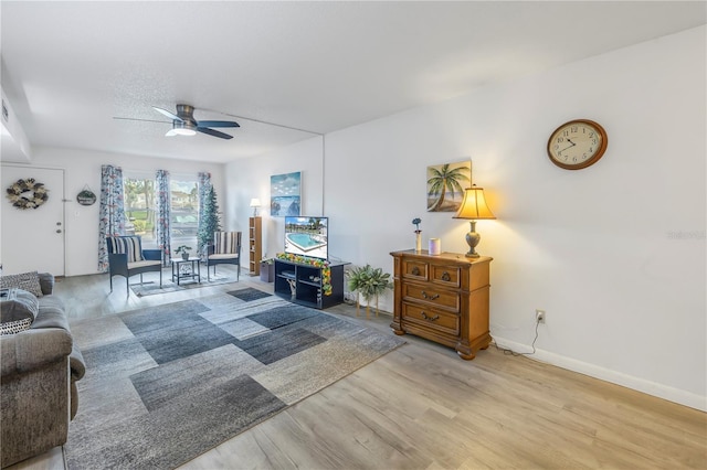 living room with ceiling fan and light wood-type flooring