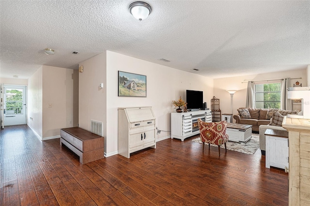 living room featuring a textured ceiling and dark hardwood / wood-style flooring