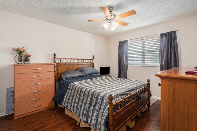 bedroom featuring dark wood-type flooring, a textured ceiling, and ceiling fan