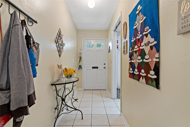 entryway with a textured ceiling and light tile patterned floors