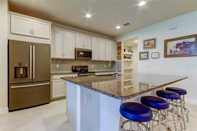 kitchen featuring white cabinetry, appliances with stainless steel finishes, a breakfast bar, and sink