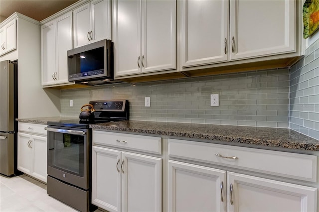 kitchen with white cabinetry, appliances with stainless steel finishes, tasteful backsplash, and dark stone counters