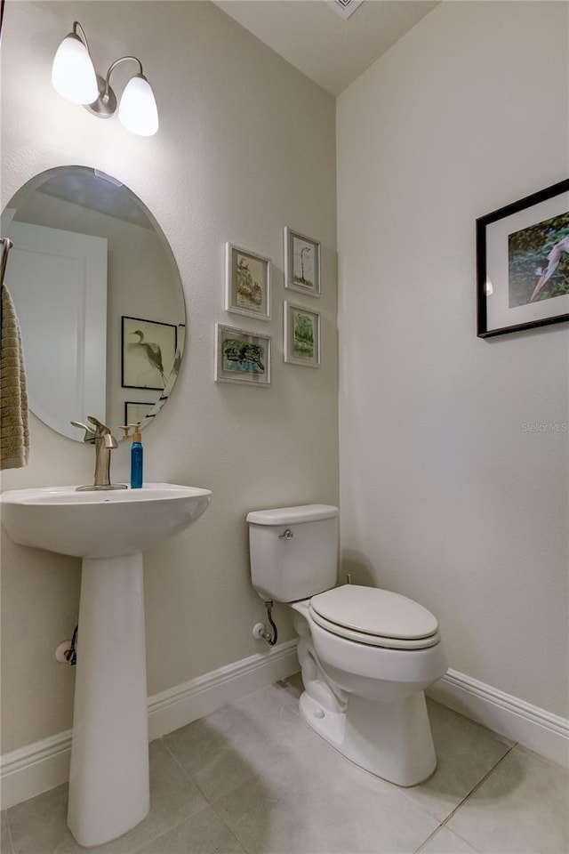 bathroom with toilet and tile patterned flooring