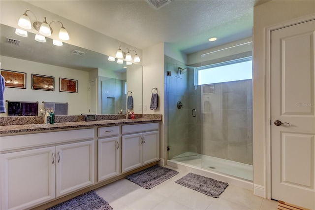 bathroom featuring an enclosed shower, vanity, and a textured ceiling