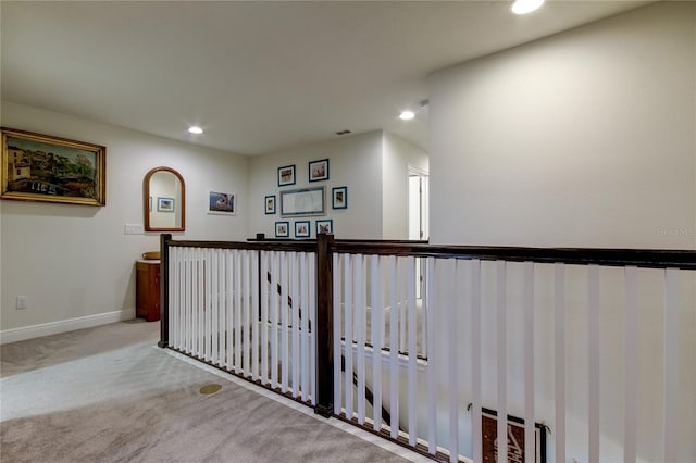 hall with light colored carpet