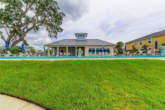 view of property's community with a pool and a lawn