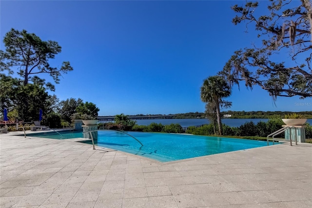 view of pool with a water view and a patio