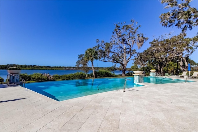 view of swimming pool featuring a water view and a patio area