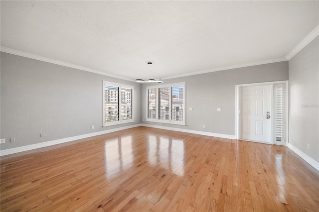 empty room with light hardwood / wood-style flooring and crown molding