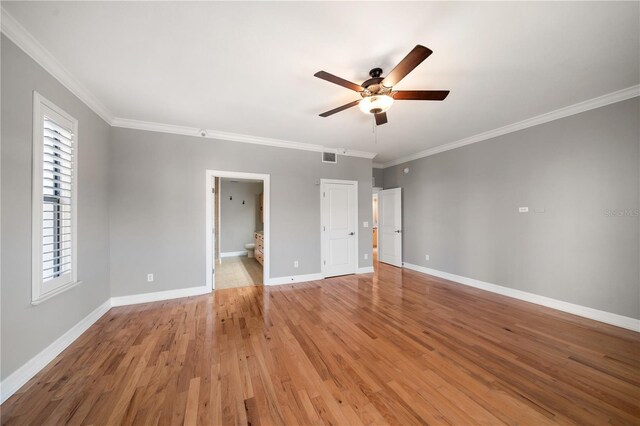 unfurnished bedroom with visible vents, ensuite bathroom, ornamental molding, light wood-type flooring, and baseboards