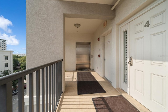 doorway to property with visible vents, a balcony, and stucco siding