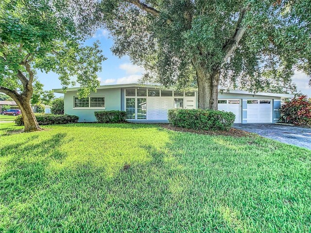 single story home featuring a garage and a front yard