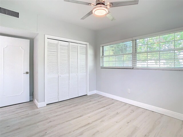 unfurnished bedroom featuring a closet, visible vents, light wood-style flooring, and baseboards