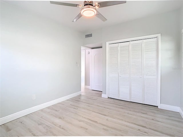 unfurnished bedroom with a closet, light wood-type flooring, and ceiling fan