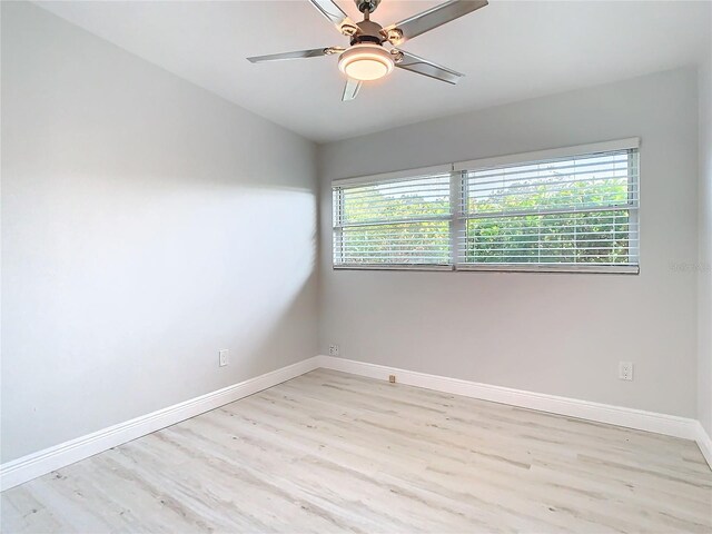 unfurnished room with light wood finished floors, baseboards, and a ceiling fan