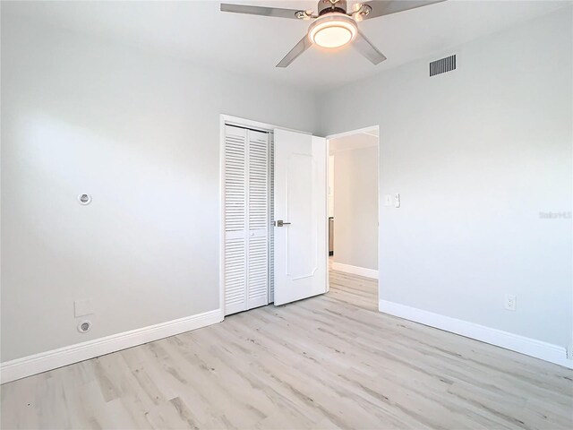 unfurnished bedroom with ceiling fan, light hardwood / wood-style floors, and a closet