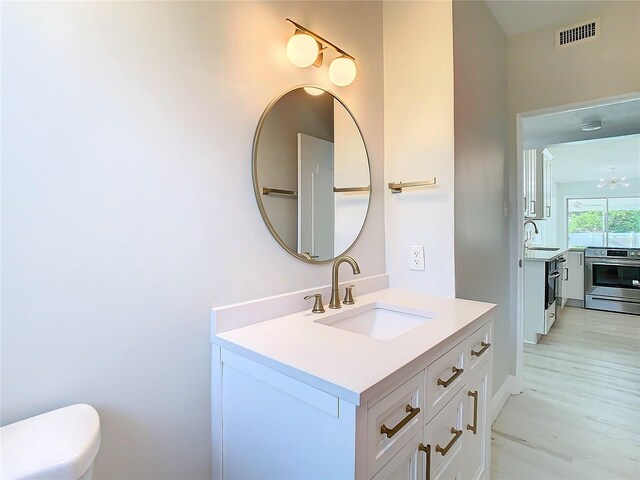 bathroom with vanity, hardwood / wood-style flooring, and toilet