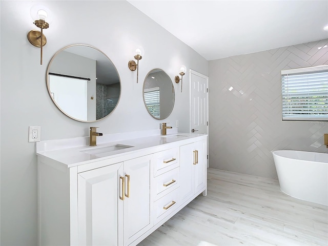 bathroom featuring hardwood / wood-style flooring, double sink vanity, and a bathing tub