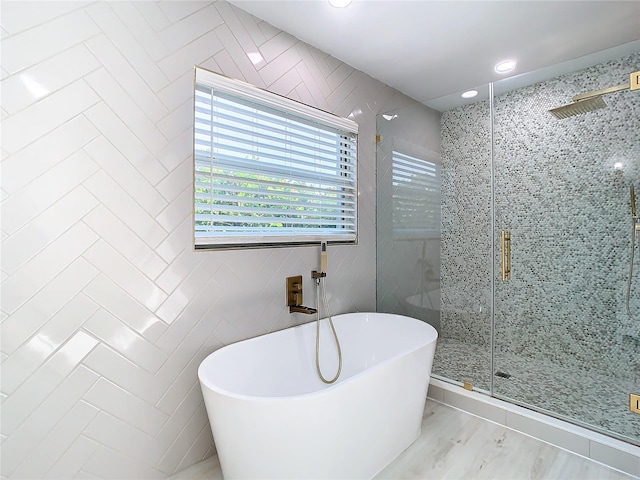 bathroom featuring tile patterned flooring, tile walls, and plus walk in shower