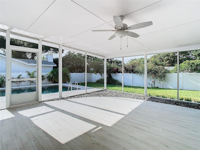 unfurnished sunroom with ceiling fan