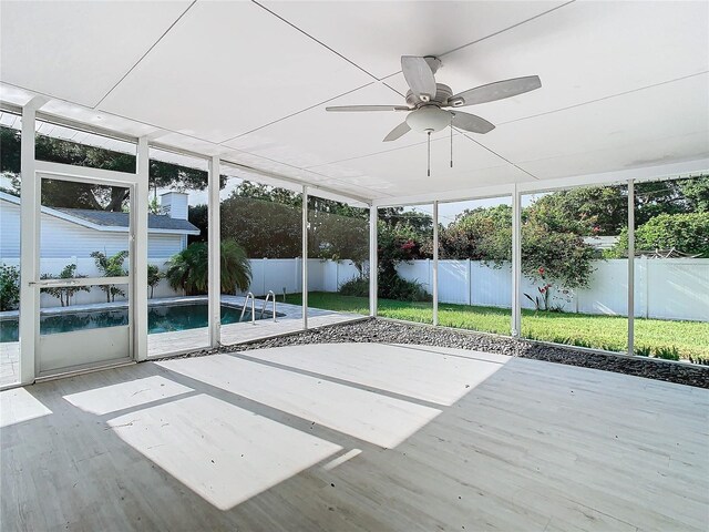 unfurnished sunroom with a ceiling fan