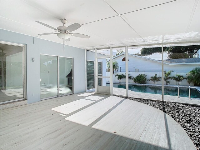 unfurnished sunroom featuring ceiling fan