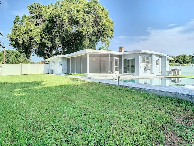 back of house featuring cooling unit, a sunroom, and a yard