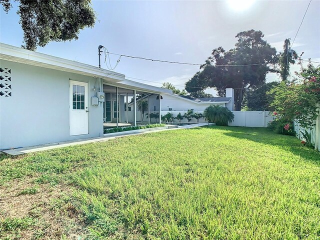 view of yard featuring a sunroom and fence