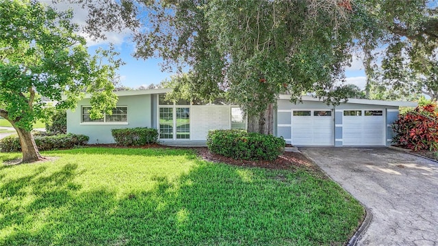 ranch-style home with a garage, concrete driveway, a front yard, and stucco siding