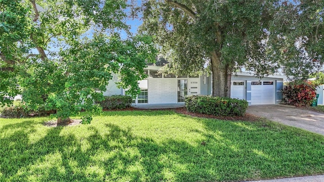 view of front of home featuring an attached garage, a front yard, concrete driveway, and stucco siding