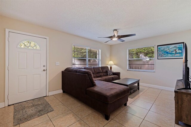 living room featuring ceiling fan, light tile patterned floors, and plenty of natural light