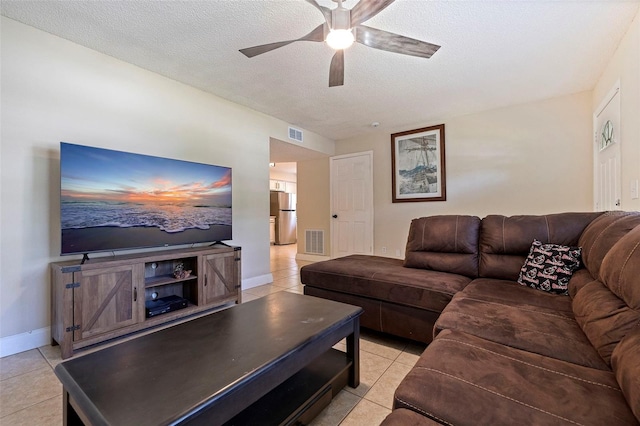 living room with a textured ceiling, light tile patterned floors, and ceiling fan