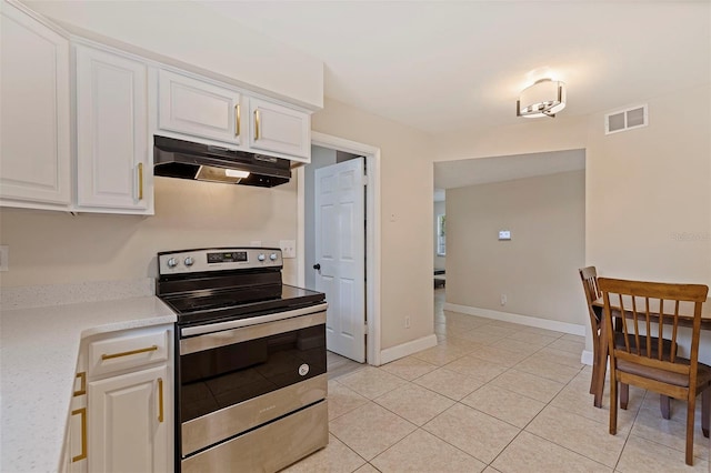 kitchen with stainless steel electric range oven, light tile patterned floors, and white cabinetry