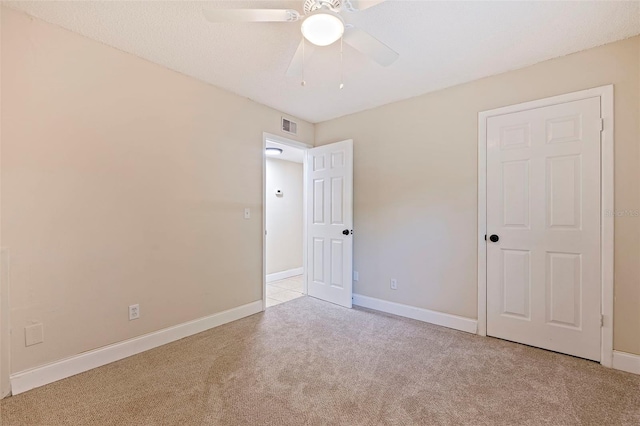 unfurnished bedroom featuring light carpet and ceiling fan