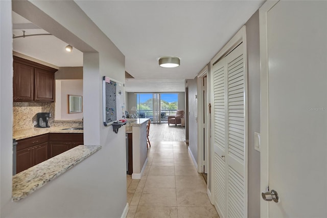 corridor featuring light tile patterned flooring and sink