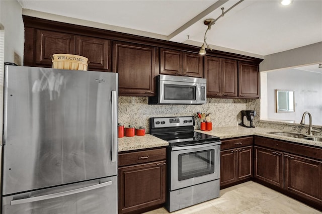 kitchen with light tile patterned floors, stainless steel appliances, backsplash, and sink