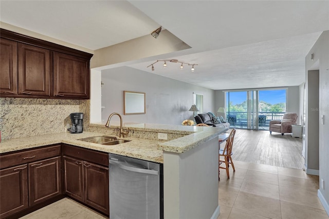 kitchen featuring sink, light wood-type flooring, kitchen peninsula, and stainless steel dishwasher