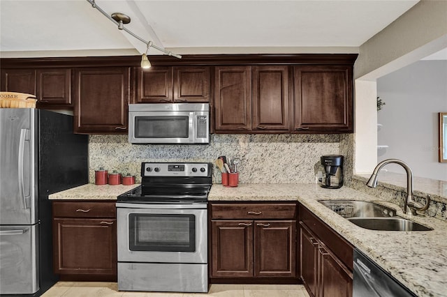 kitchen with dark brown cabinets, sink, stainless steel appliances, and tasteful backsplash